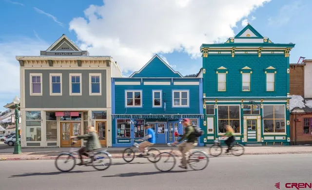 a front view of a house with large windows and a clock