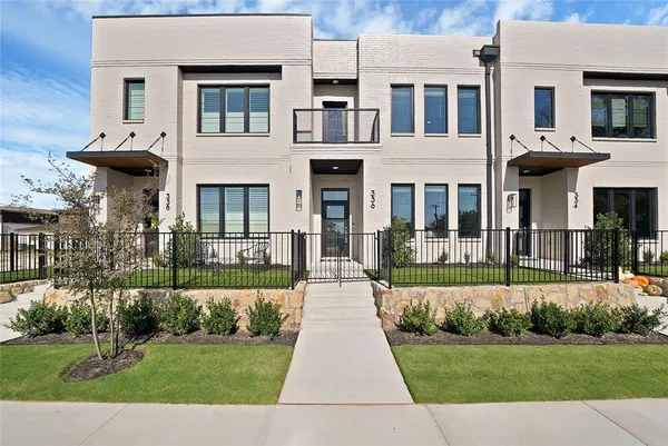 a front view of a house with a yard and potted plants