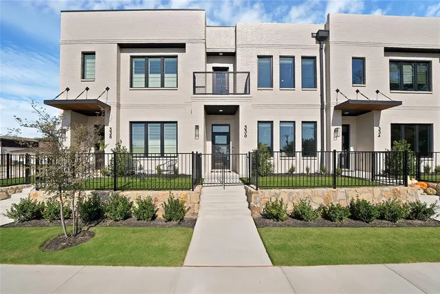 a front view of a house with a yard and potted plants