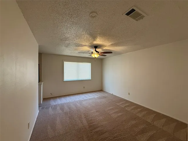 an empty room with windows and fan