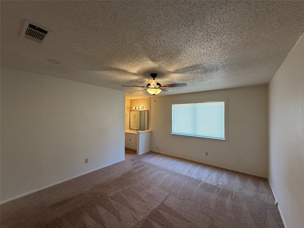 8906 Pineridge Drive Austin, TX 78729 - Photo 12 of 35 en empty room with windows and ceiling fan
