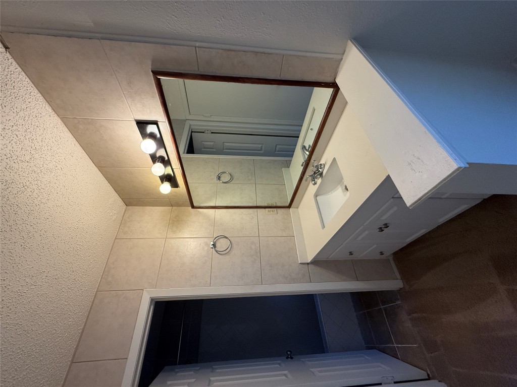 8906 Pineridge Drive Austin, TX 78729 - Photo 13 of 35 a bathroom with a sink and mirror