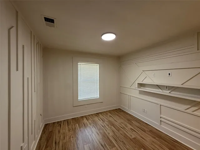 a view of a room with wooden floor and window