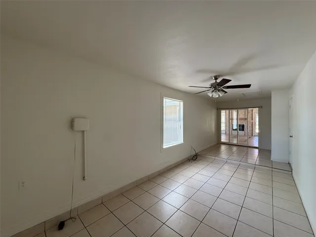 a view of a livingroom with a chandelier fan and windows