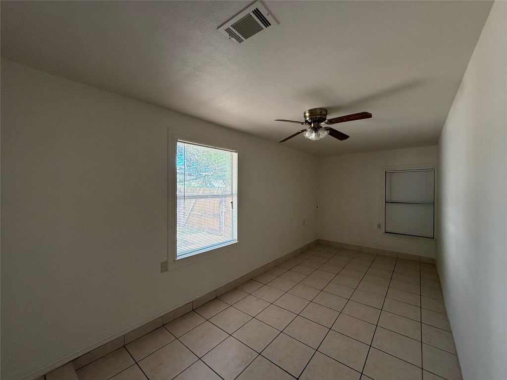 8906 Pineridge Drive Austin, TX 78729 - Photo 28 of 35 an empty room with windows and fan
