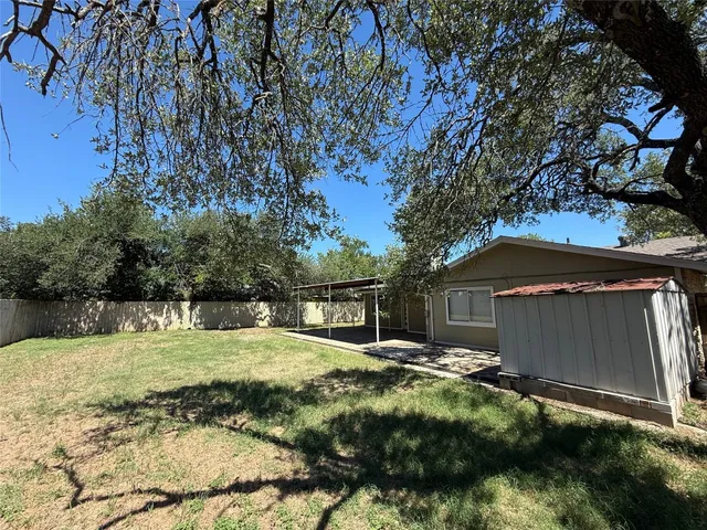 a view of a backyard with large trees