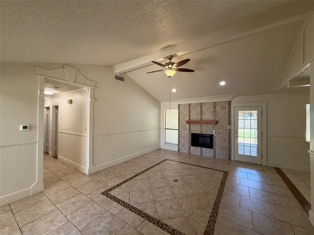 an empty room with windows and fireplace