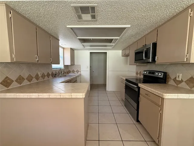 a kitchen with stainless steel appliances granite countertop a sink and a stove
