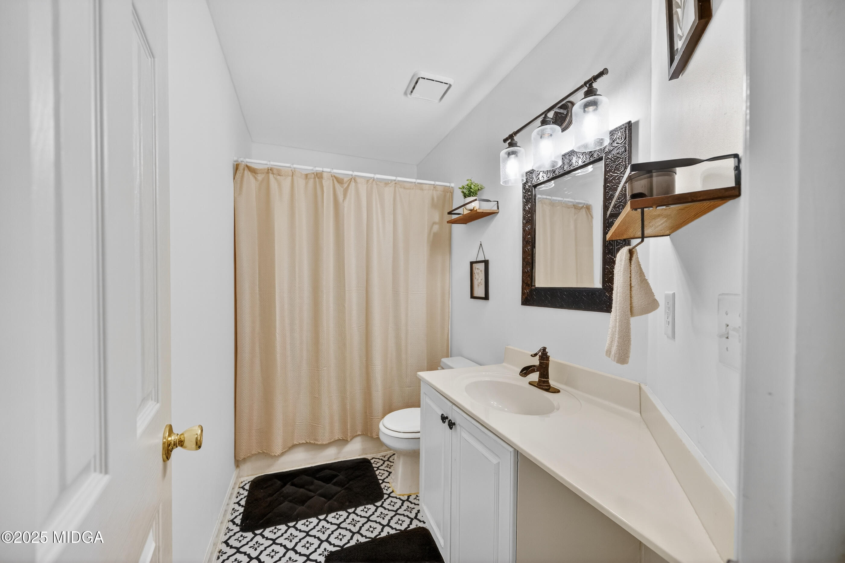 199 Springfield Boulevard Macon, GA 31210 - Photo 33 of 44 a bathroom with a sink a toilet and shower curtain