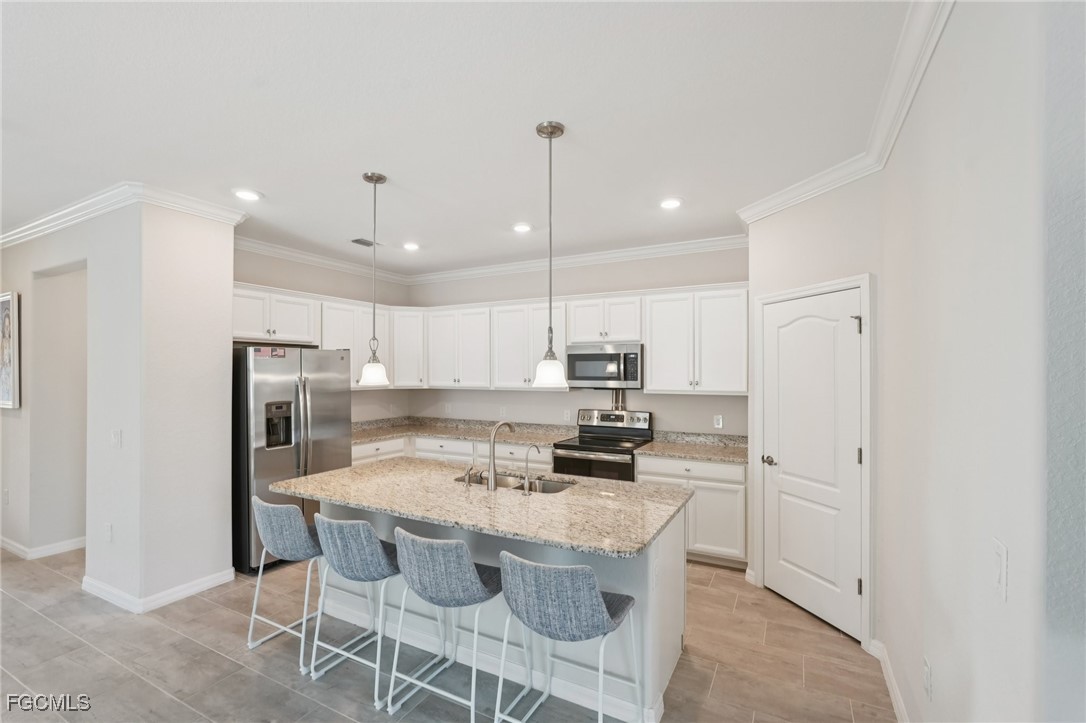 11872 Arbor Trace Drive Fort Myers, FL 33913 - Photo 8 of 50 a kitchen with kitchen island granite countertop a sink a center island and stainless steel appliances