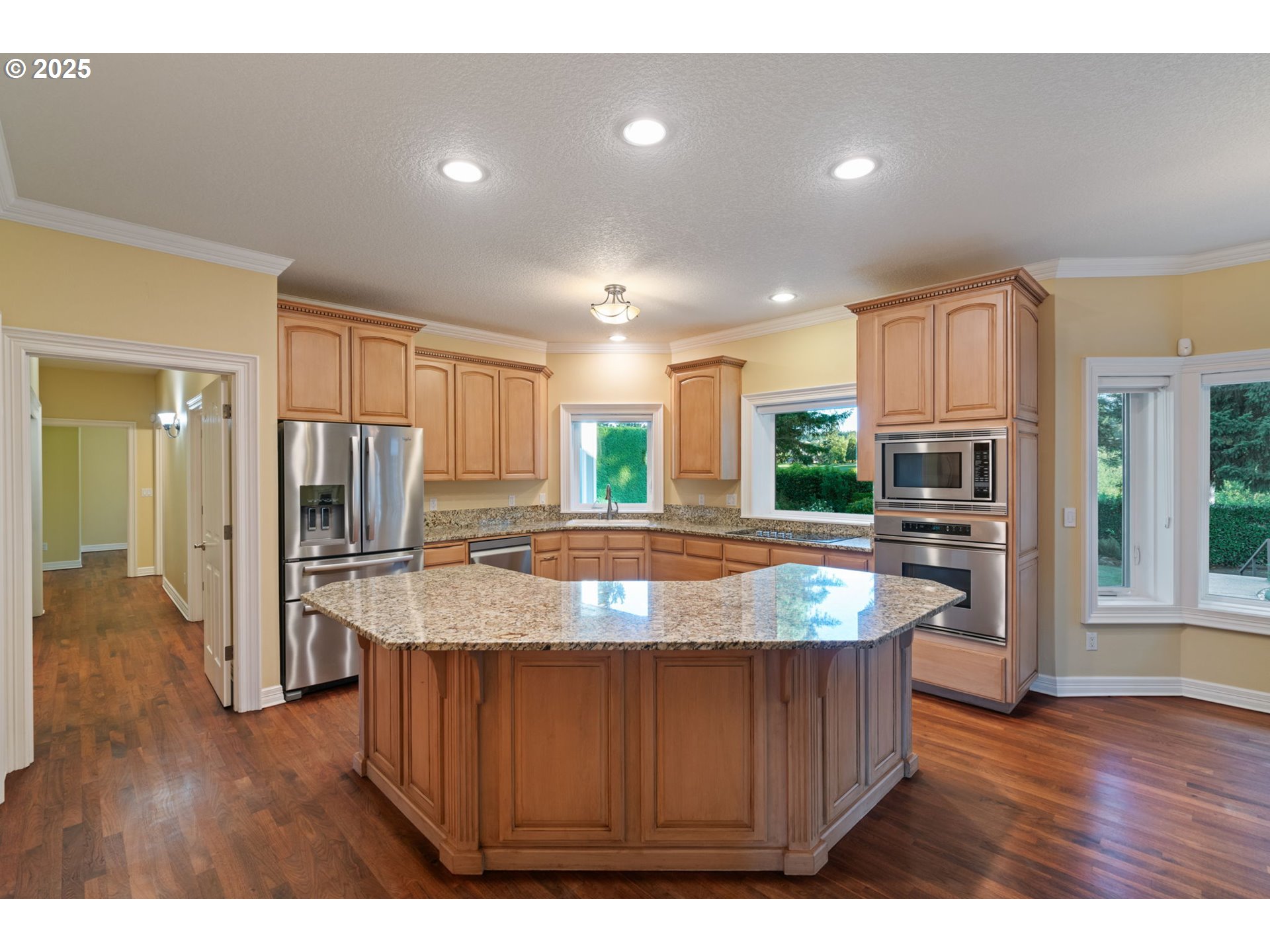 3110 Northwest Lacamas Drive Camas, WA 98607 - Photo 13 of 48 a kitchen with kitchen island granite countertop wooden floors a refrigerator and a sink
