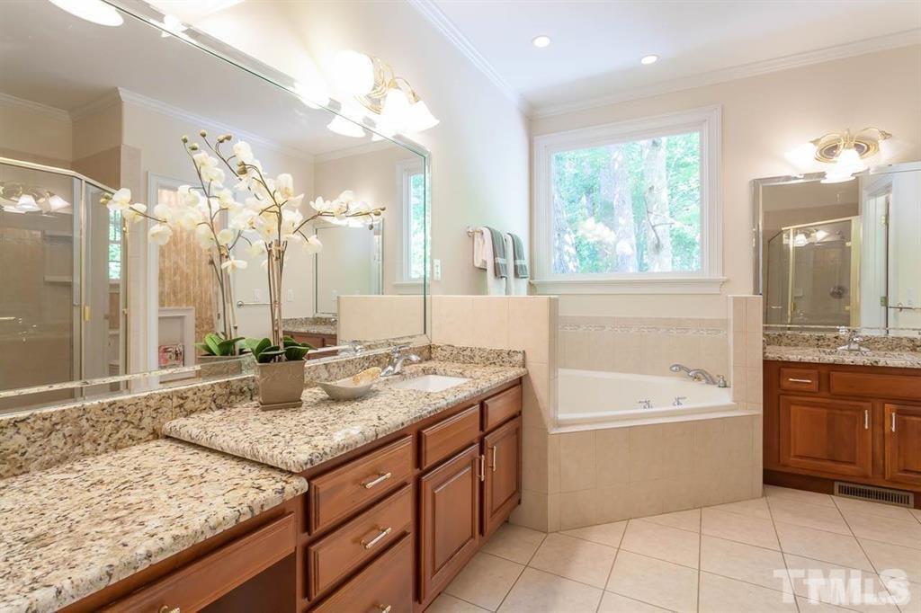 10500 Charmford Way Raleigh, NC 27615 - Photo 17 of 22 a bathroom with a granite countertop sink a mirror and a bathtub