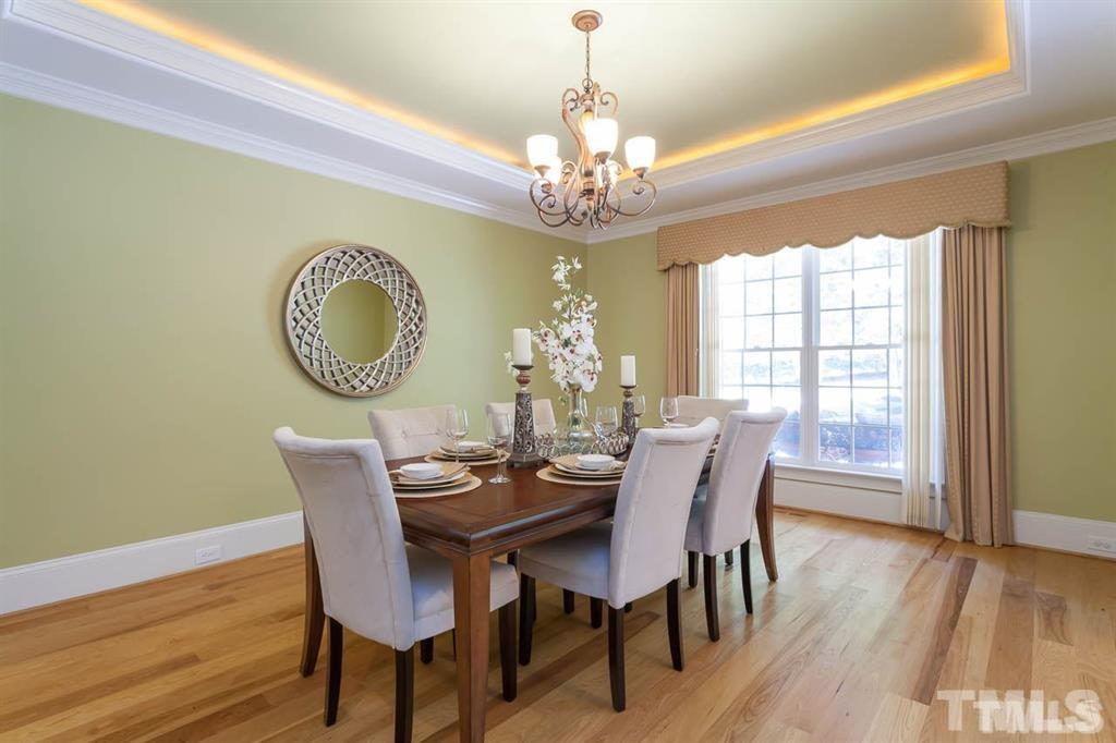 10500 Charmford Way Raleigh, NC 27615 - Photo 7 of 22 a dining room with furniture a chandelier and wooden floor
