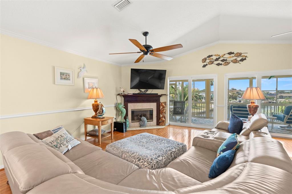 6170 Seaside Drive New Port Richey, FL 34652 - Photo 12 of 89 a living room with furniture a fireplace and a flat screen tv