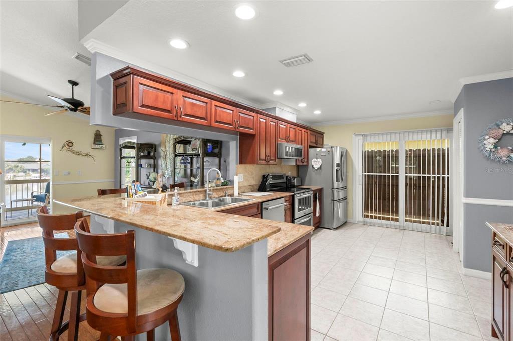 6170 Seaside Drive New Port Richey, FL 34652 - Photo 16 of 89 a kitchen with stainless steel appliances granite countertop a sink and a refrigerator