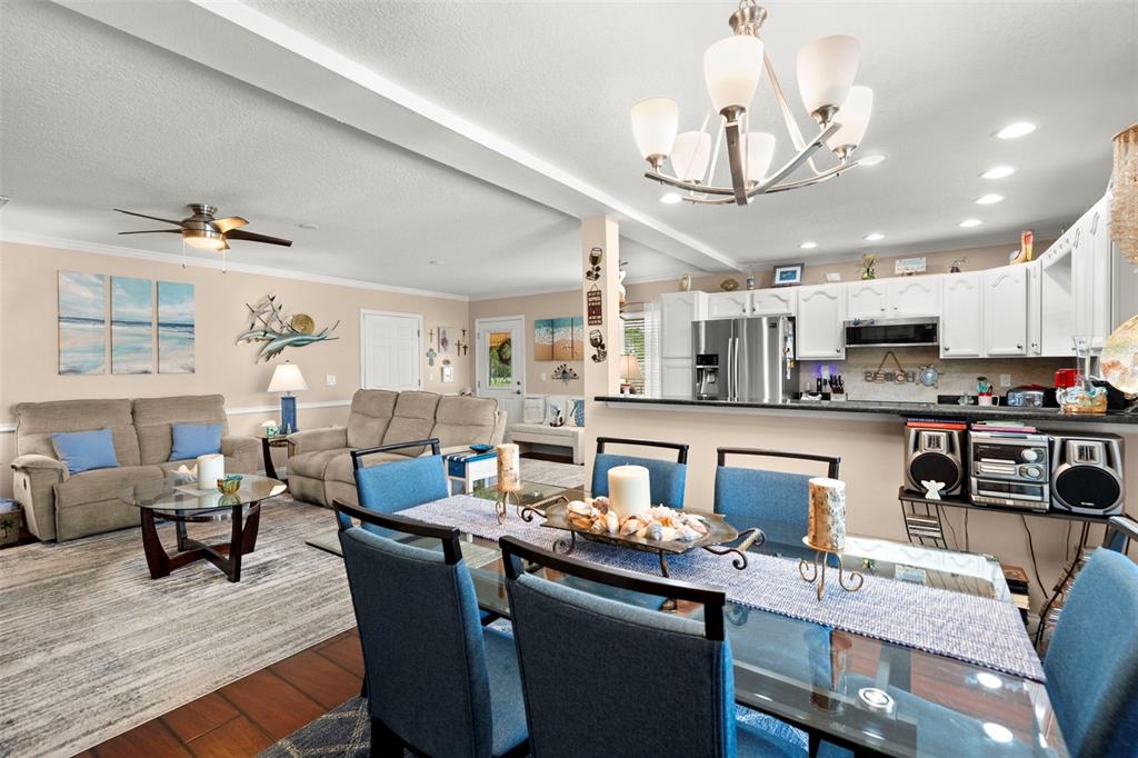 6170 Seaside Drive New Port Richey, FL 34652 - Photo 41 of 89 a kitchen with stainless steel appliances kitchen island granite countertop a dining table chairs sink refrigerator and cabinets