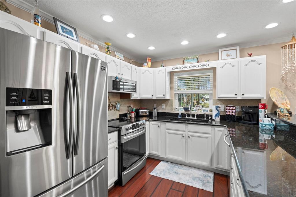 6170 Seaside Drive New Port Richey, FL 34652 - Photo 43 of 89 a kitchen with granite countertop a refrigerator stove and sink