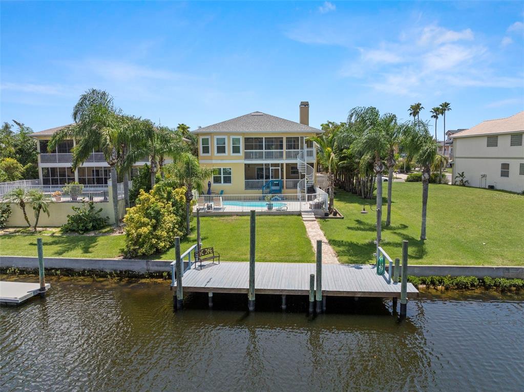 6170 Seaside Drive New Port Richey, FL 34652 - Photo 66 of 89 a view of a house with pool lawn chairs and a yard with swimming pool