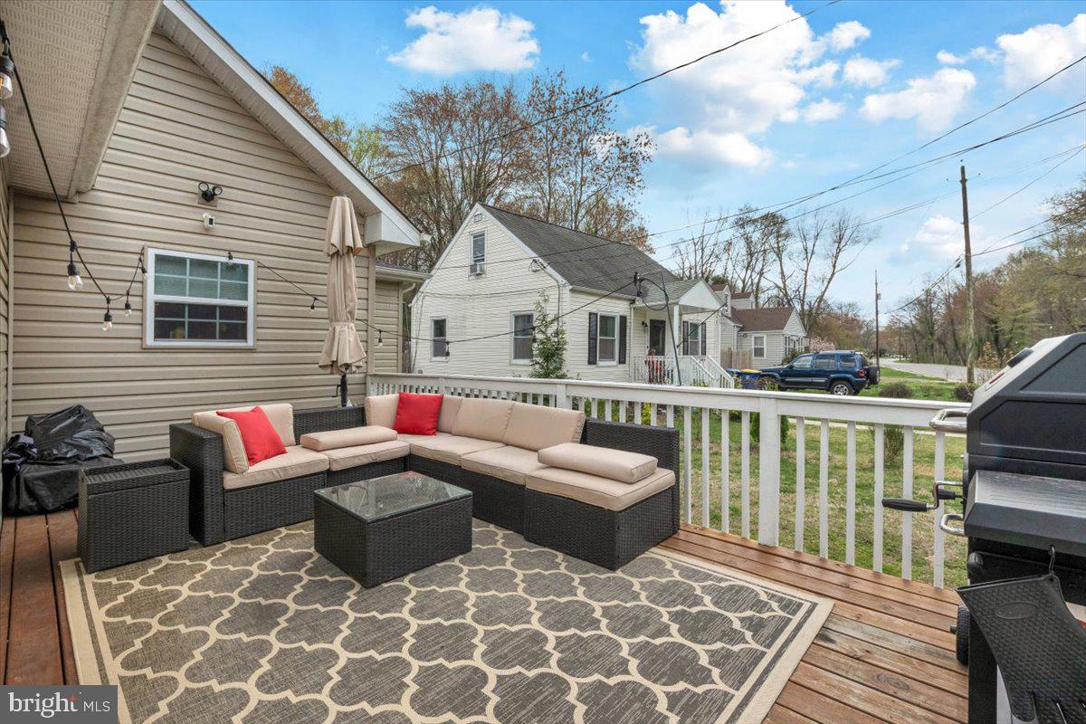 6519 Woodland Road Suitland, MD 20746 - Photo 1 of 35 a view of a patio with couches chairs and wooden floor