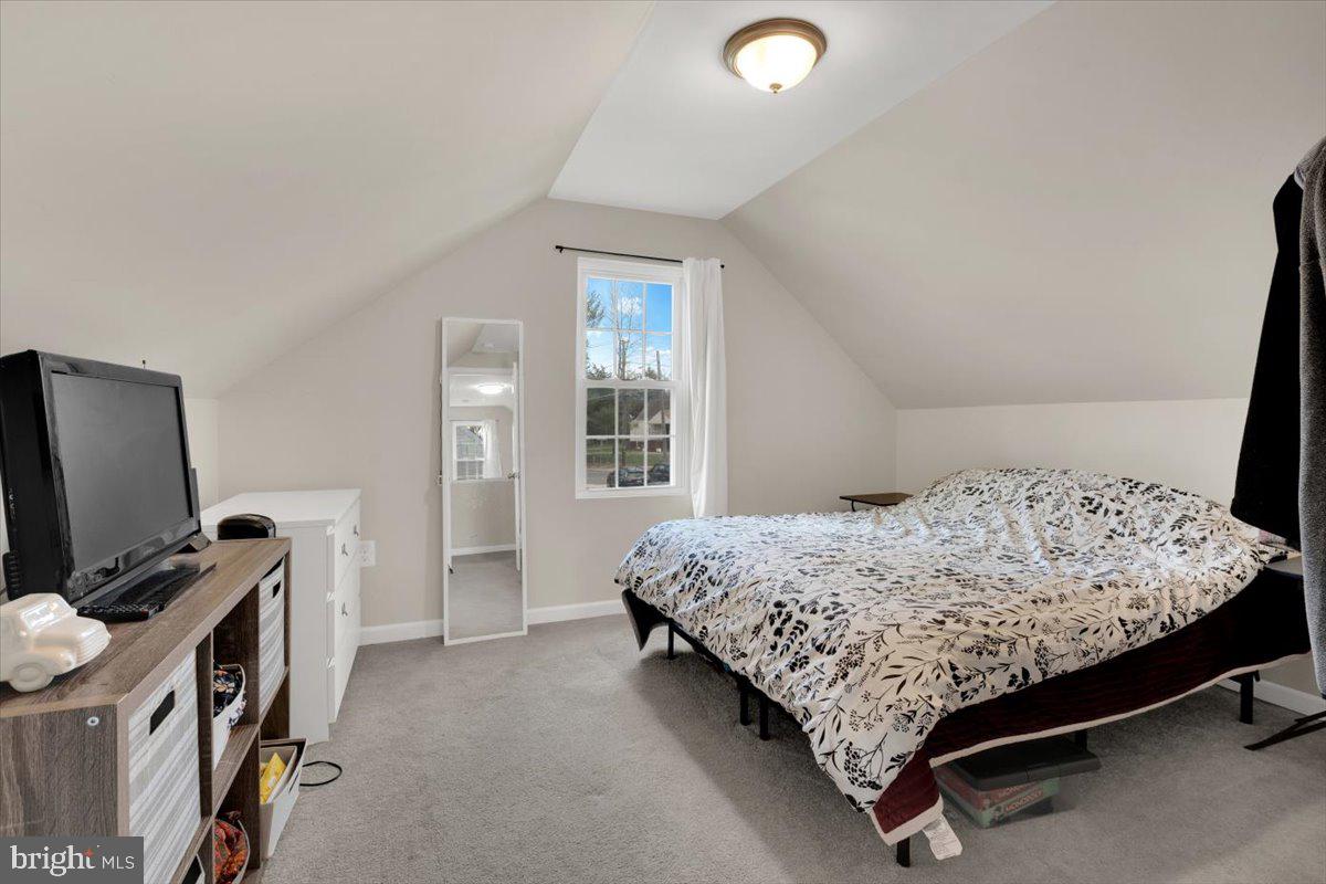 6519 Woodland Road Suitland, MD 20746 - Photo 21 of 35 a bedroom with a bed and a flat tv screen on a dresser