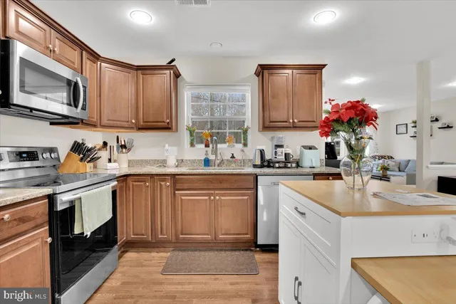 a kitchen with kitchen island granite countertop a sink stove and cabinets