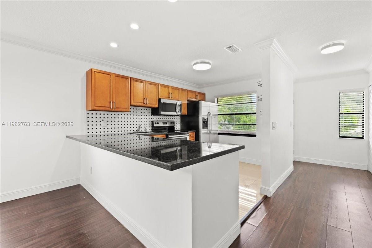 7944 Eastlake Drive, Unit D Boca Raton, FL 33433 - Photo 8 of 29 a kitchen with stainless steel appliances a sink and a stove