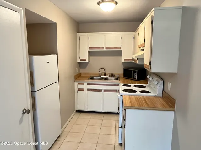 a kitchen with a refrigerator a stove a microwave and cabinets