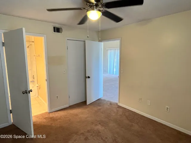 a view of a livingroom with a chandelier fan and a window
