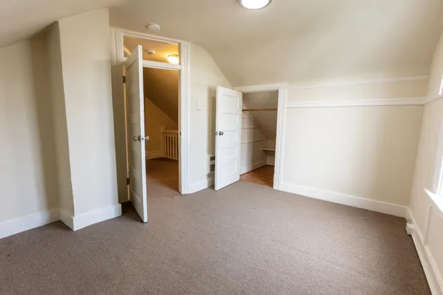 an empty room with closet and a bathroom