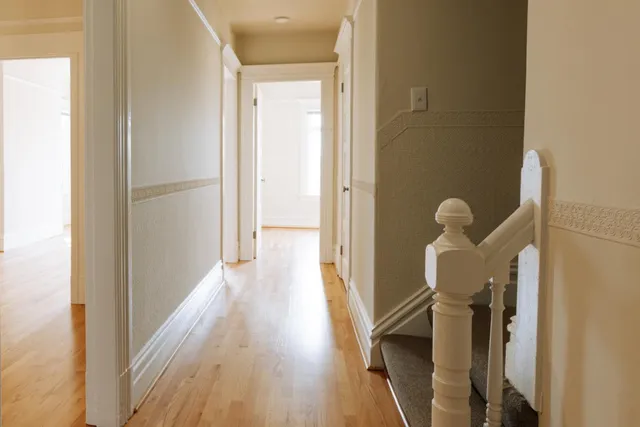 a view of a hallway with wooden floor