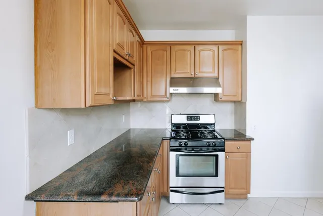 a kitchen with granite countertop a stove and a sink