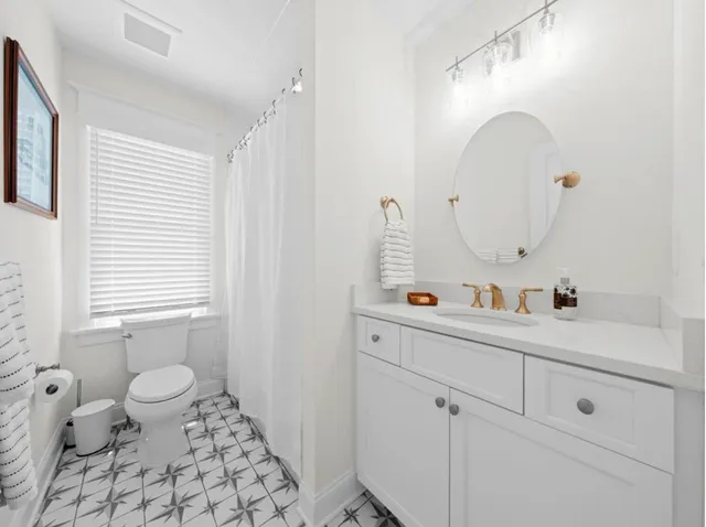 a bathroom with a sink a toilet and a mirror