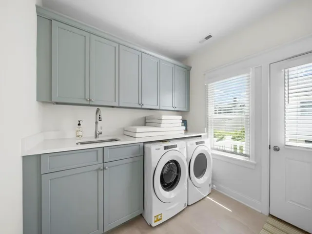 a utility room with sink dryer and washer