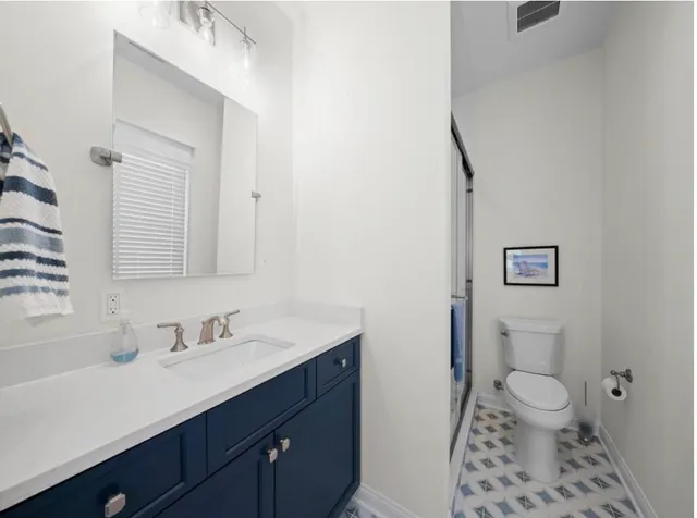 a bathroom with a sink a toilet a shower and a mirror