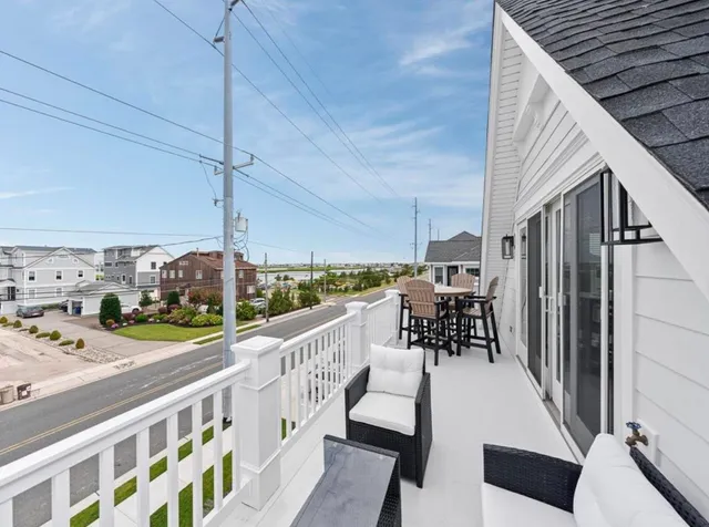 a view of a balcony with chairs and wooden floor