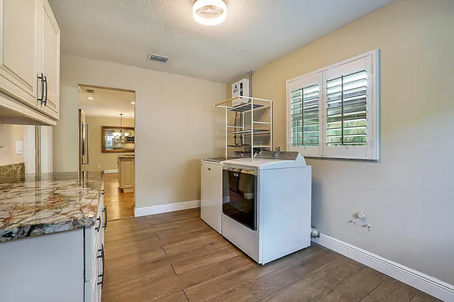 a view of a kitchen with stainless steel appliances granite countertop a stove and a wooden floors