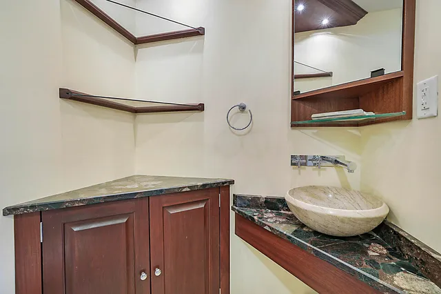 a bathroom with a granite countertop sink and a mirror