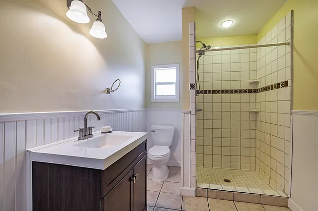 a bathroom with a sink a toilet and shower
