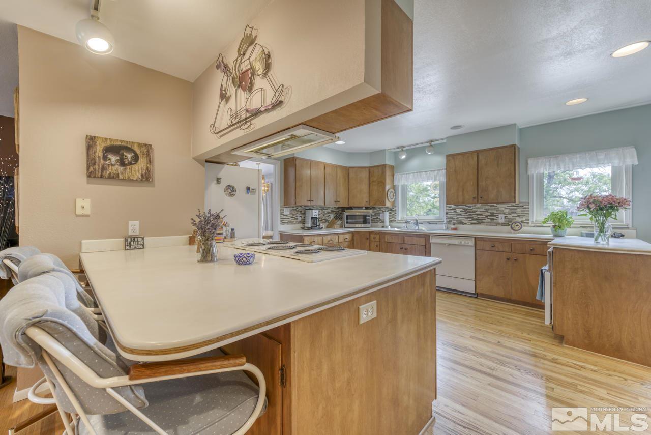 3650 Clover Way Reno, NV 89509 - Photo 7 of 31 a kitchen with stainless steel appliances granite countertop a sink a stove and a wooden floors