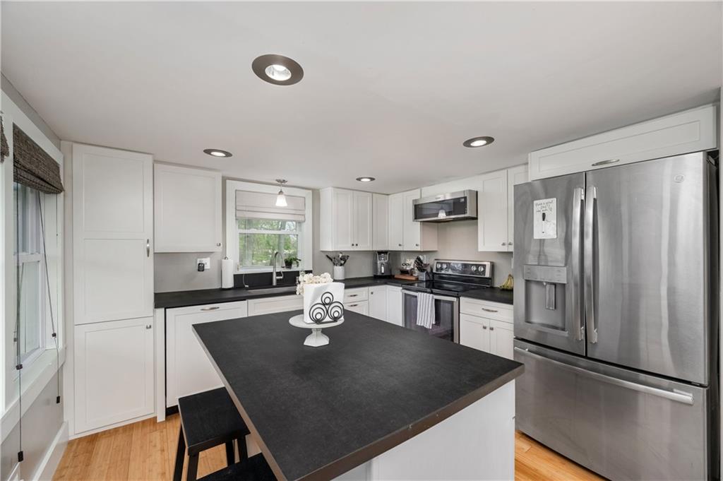 300 Bonniebrook Road Butler, PA 16002 - Photo 9 of 28 a kitchen with stainless steel appliances granite countertop a sink a stove a refrigerator a dining table and chairs with wooden floor