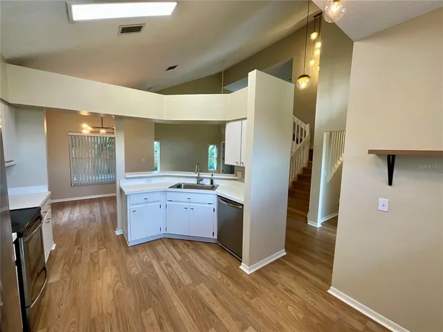 a kitchen with stainless steel appliances a refrigerator and a wooden floor