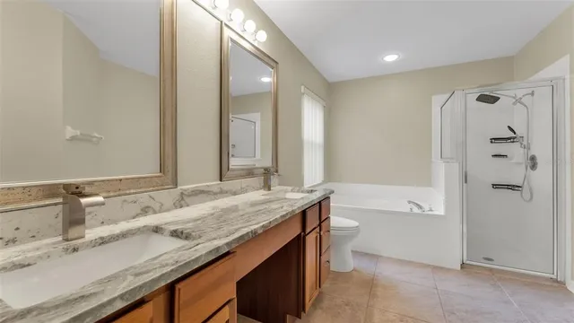 a bathroom with a granite countertop sink mirror toilet and bathtub