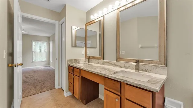 a en suite bathroom with a granite countertop sink and a mirror