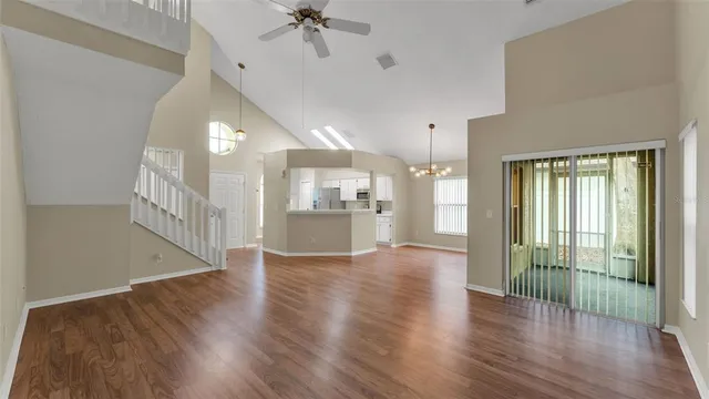 a view of a hallway with wooden floor and a kitchen