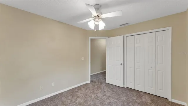 an empty room with a ceiling fan and a window