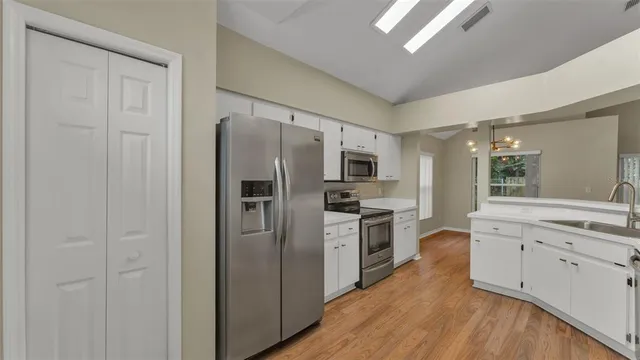 a kitchen with stainless steel appliances a refrigerator sink and cabinets