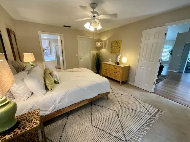 a bedroom with a bed a couch and dresser with wooden floor