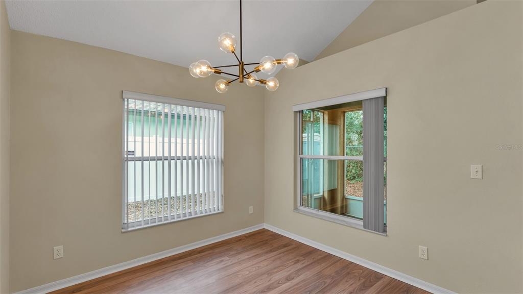 2319 Needham Drive Valrico, FL 33596 - Photo 10 of 35 a view of an empty room with chandelier fan and wooden floor