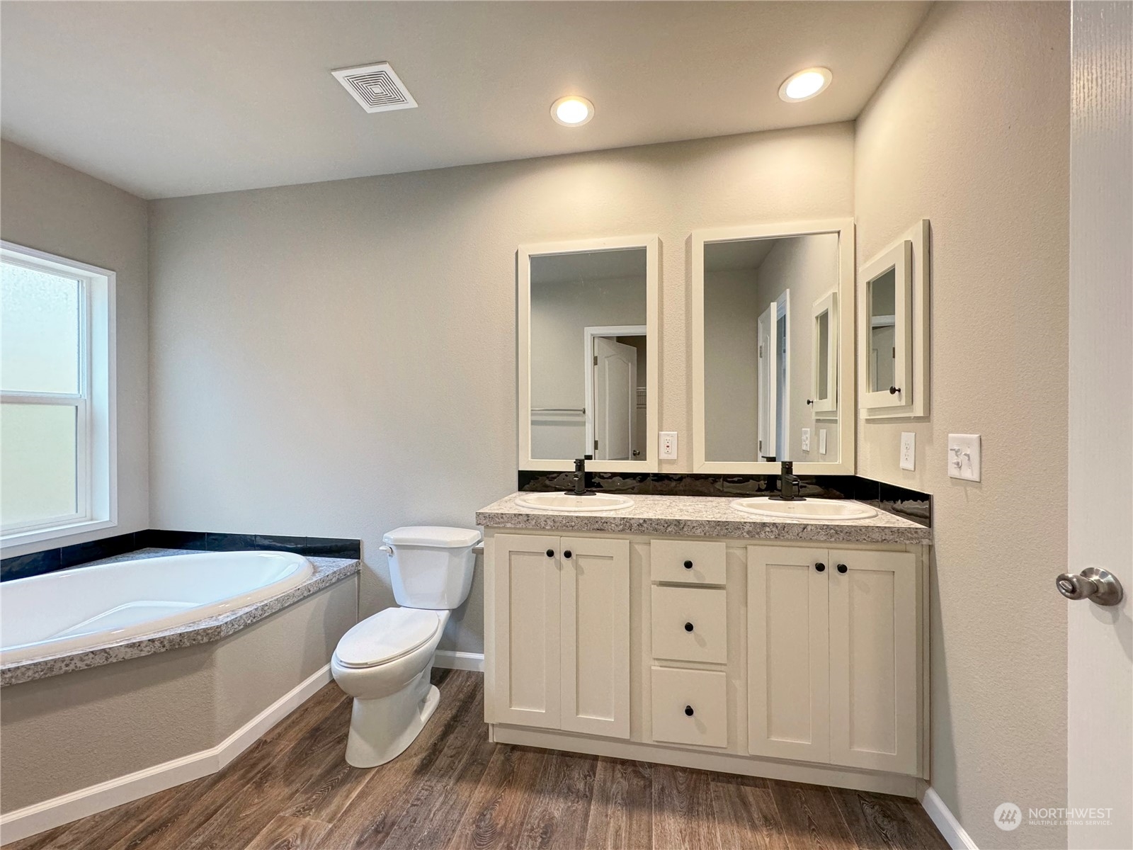 180 Madrona Way Sequim, WA 98382 - Photo 25 of 35 a bathroom with a granite countertop toilet a sink and a mirror