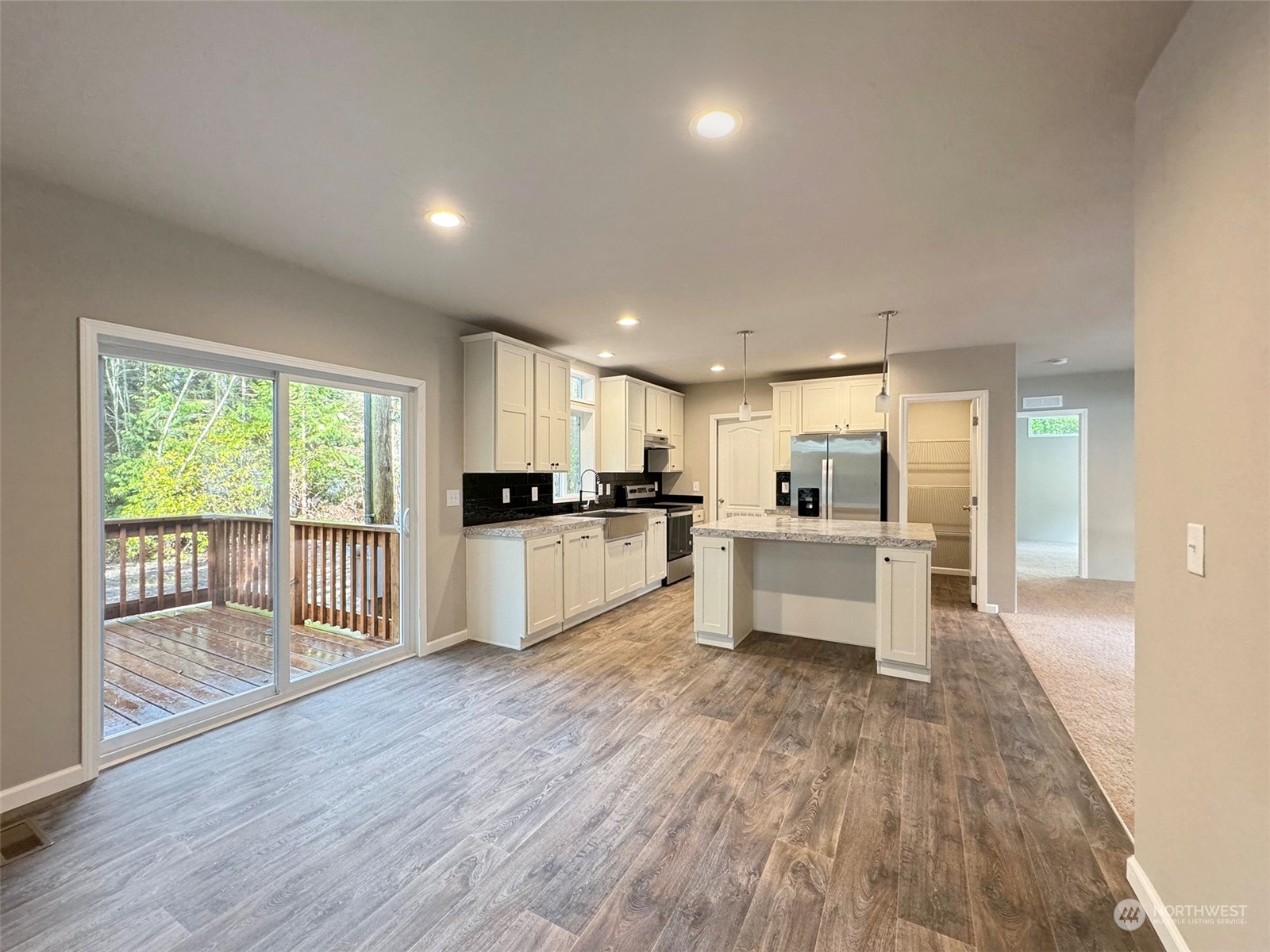 180 Madrona Way Sequim, WA 98382 - Photo 4 of 35 a large white kitchen with white cabinets and stainless steel appliances